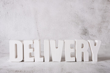 Word Delivery made from white concrete letters on the light background