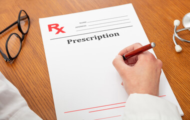 Medical prescription. Woman doctor, wooden office table. Female hand over document, above view .