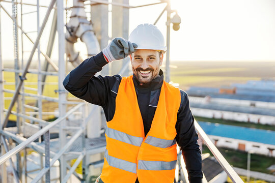 An industry worker greeting people and smiling at the camera. - Powered by Adobe