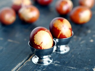 Group of Easter eggs colored with onion skin broth on a dark wooden background.