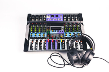 Audio mixer console with black headphones isolated on white background. - Powered by Adobe
