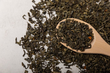 Green tea leaves. Dry green tea leaves in a wooden spoon.Background of dry green tea leaves.