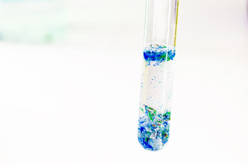 close-up of test tube with polluted water and traces of plastic and micro plastic taken from the ocean, polymer particles, environmental crisis