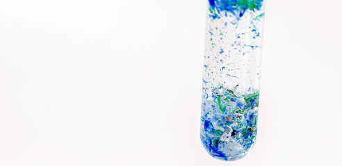 close-up of test tube with polluted water and traces of plastic and micro plastic taken from the ocean, polymer particles, environmental crisis