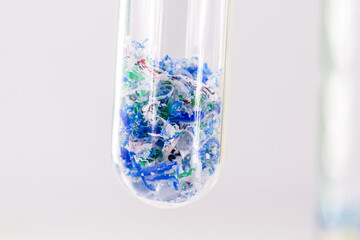 close-up of test tube with traces of plastic and micro plastic taken from the ocean, polymer particles, pollutant from the seas, environmental problem