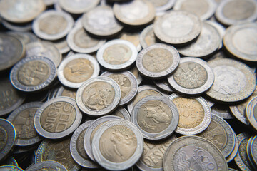 Pile of Colombian coins of 500 and 1000 denominations over wooden background. Ideal for economy, money, banks, save money and finance.
