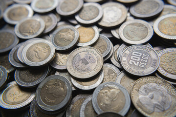 Pile of Colombian coins of 500 and 1000 denominations over wooden background. Ideal for economy, money, banks, save money and finance.
