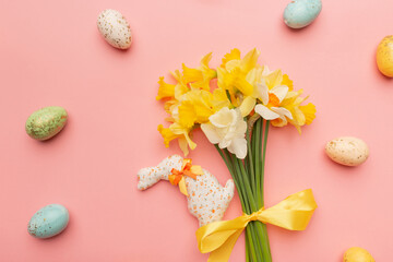 Fototapeta na wymiar Light yellow spring bouquet and easter decor on pink background. Spring flowers background with copy space