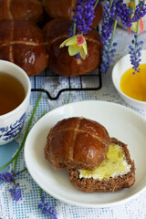 Chocolate cross buns served with butter and honey. Traditional Easter baking.