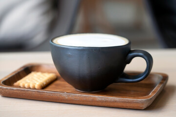 a black cappuccino coffee mug on a wooden tray. morning breakfast at the lifestyle coffee shop