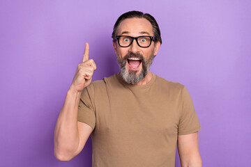 Photo of overjoyed amazed man pointing finger copyspace find solution to problem isolated on violet...