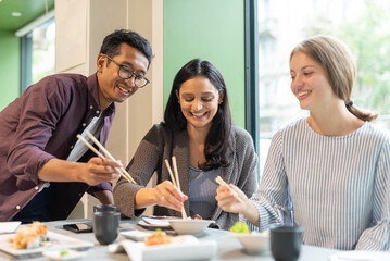 group of multiracial friends at japanese restaurant, generation z people havin fun at lunch