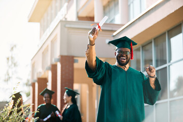 Cheerful African American student celebrating his graduation and looking at camera.