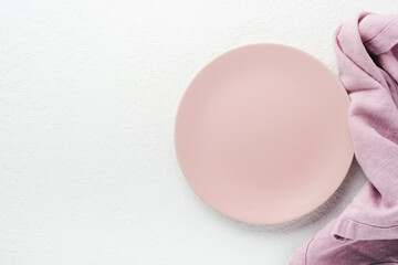Ceramic empty pink plate. Rustic vintage set of white plate, wooden spoon on light white wooden background. Vintage zero waste silverware. Empty dishes. Top view. Mock up.