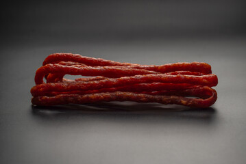 Cabanossi, dry sausage isolated on black background.