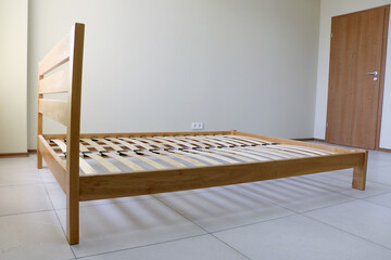 frame of a simple lacquered bed made of wood with slats without mattress