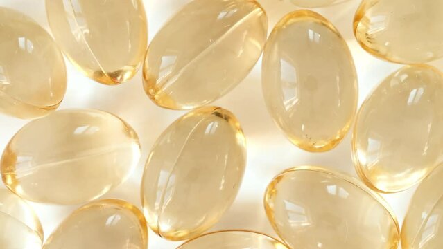Yellow capsules medical pills rotating closeup. Vitamin C, Omega 3 in oil capsules. Pills and drugs. Pharmaceutical Industry. The medicine concept. Slow motion. High quality 4k footage