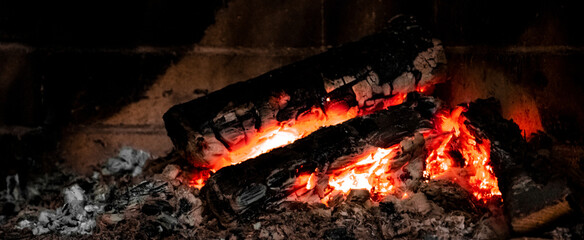 Embers in a coal furnace. Red coals from high temperature. Heating the house with coal. Non-ecological fuel. Burning charcoal firewood in the fireplace or the stove.