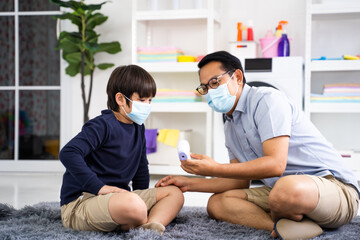 Father puts on son medical face mask in home Coronavirus quarantine and epidemic, Family wearing face mask for protection during the quarantine