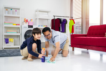 Happy family cleans the room. Asian father and son do the cleaning in the house. A young man and...