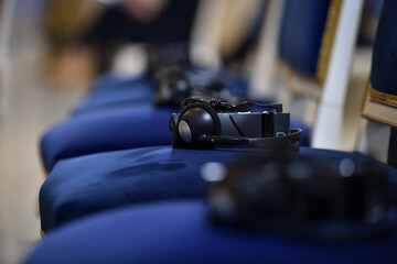 Headphones are seen on elegant chairs before the start of a conference.