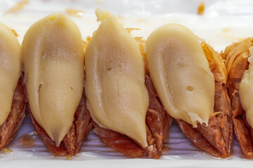 Trigona Panoramatos - crispy phyllo triangle pastries with custard close up, popular Greek sweet dessert manufactured in Thessaloniki, soaked in syrup and filled with cream.