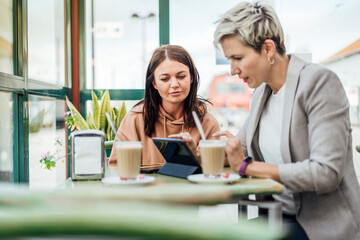 Fototapeta premium Two female friends drinking coffee and enjoying time