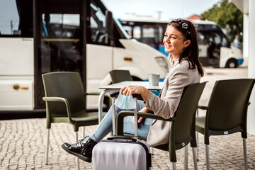 A young traveler sitting in the cafe and waiting for her bus to come