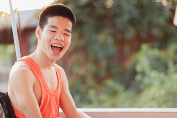 Young man with a disability by moving the head and limbs on a wheelchair to prevent joint adhesion...