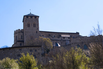 Fototapeta na wymiar Beautiful medieval catholic church and castle Basilique de Valère (Valeria) on a hill at City of Sion on a sunny spring day. Photo taken April 4th, 2022, Sion, Switzerland.