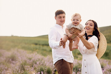 Beautiful young family in a lavender field spends the day