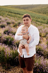 handsome young dad in playing with son in lavender field