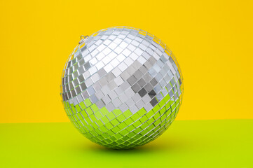 Disco ball close up on green and yellow background