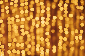 Abstract defocused yellow light on black background. Bokeh photo of LED light.