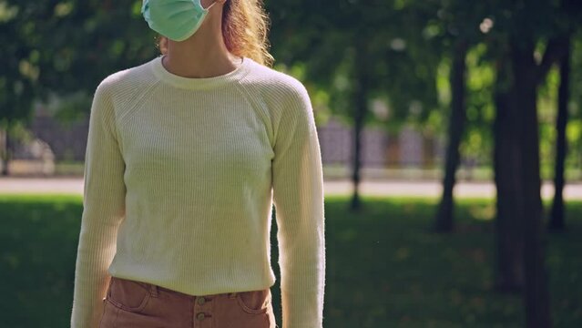 Young woman in protective mask walking german shepherd dog on leash, lockdown