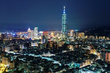 Fototapeta na wymiar Aerial panorama over Taipei after dark, the capital city of Taiwan, with Taipei 101 Tower among skyscrapers in Xinyi Financial District, crowded buildings in downtown & city lights at night
