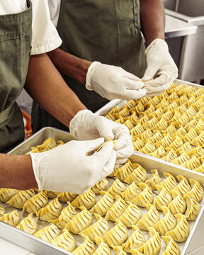 Vertical Shot Of People Making Dumplings