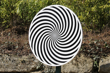 Spiral optical illussion wheel with a natural background