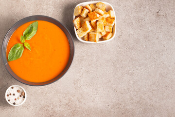 Fresh, healthy tomato soup with basil, pepper, garlic, tomatoes and bread on wooden background. Spanish gazpacho soup. Lentils and pumpkin soup.