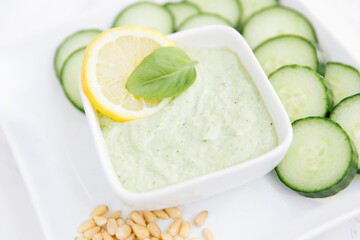 pesta dip with pine nuts, basil, lemon , and cucumber slices