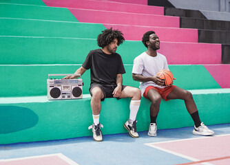 Diverse african men sitting in the city while listening music from vintage stereo boombox