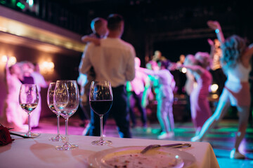party, set table, glasses against the background of dancing people at the disco