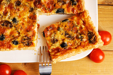 Homemade cheesy Quiche with tomatoes, champignons and olives. Top view.