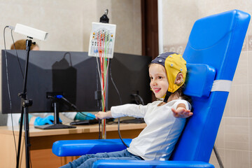 Fototapeta na wymiar The girl smiles while doctor doing an electroencephalogram