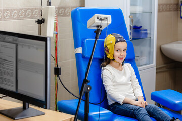 The girl smiles while doctor doing an electroencephalogram
