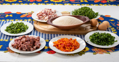 ingredients for preparing a recipe, bacon, cabbage, red bell pepper, manioc flour, egg, sausage, parsley, on a table