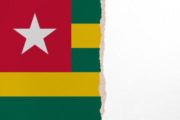 Half- ripped paper background in colors of national flag. Togo