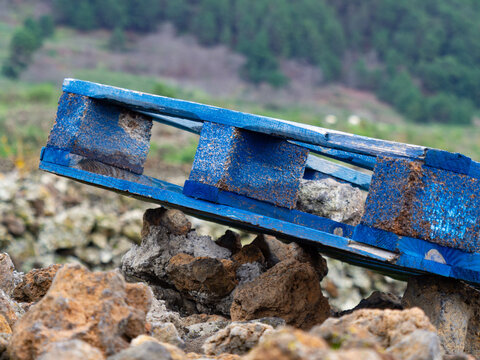 A Blue Wooden Pallet In A Green Landscape