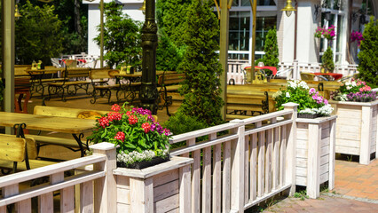 An empty street cafe with vases with petunia flowers on the promenade of the city of Svetlogorsk, Kaliningrad region, Russia