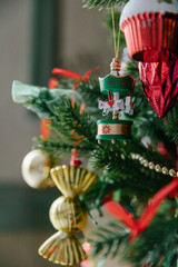 Beautiful decorations and toys on the Christmas tree, red and gold. Close-up, details of the Christmas tree